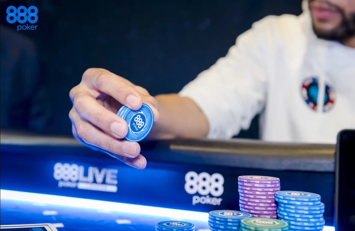 Ein Mann hält einen Pokerchip in seiner Hand