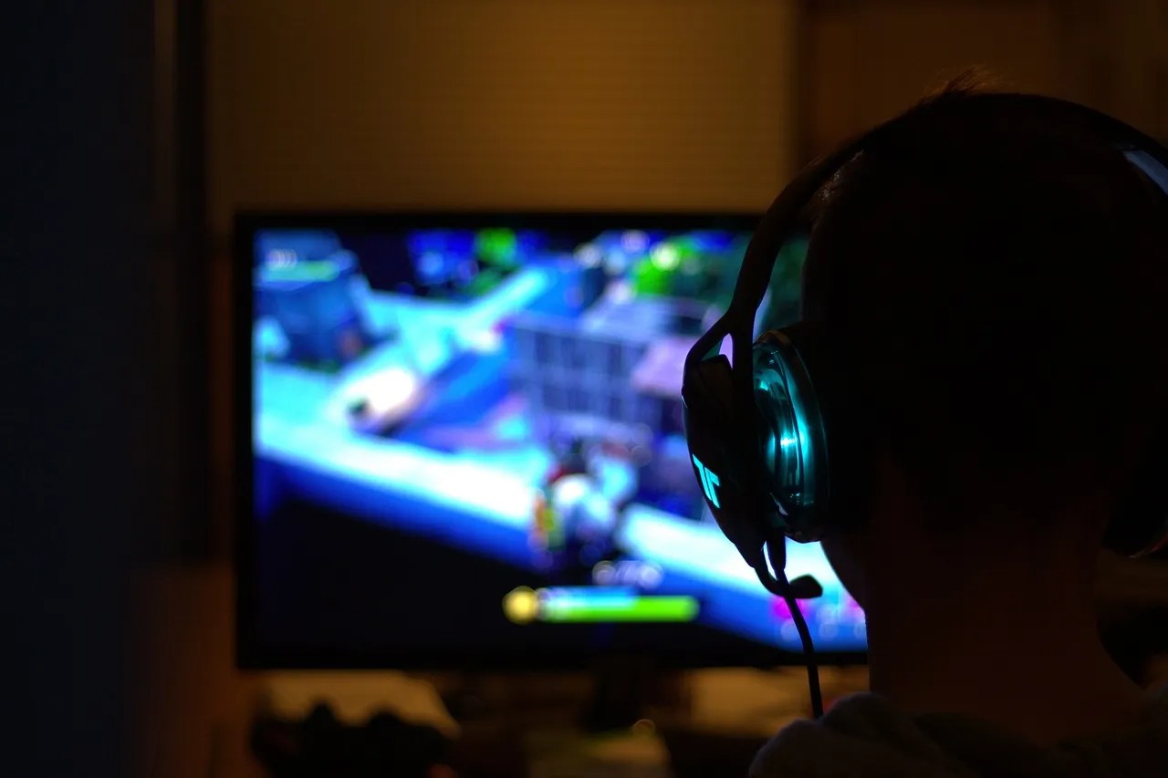 Ein Mann spielt Fortnite vor einem PC-Bildschirm